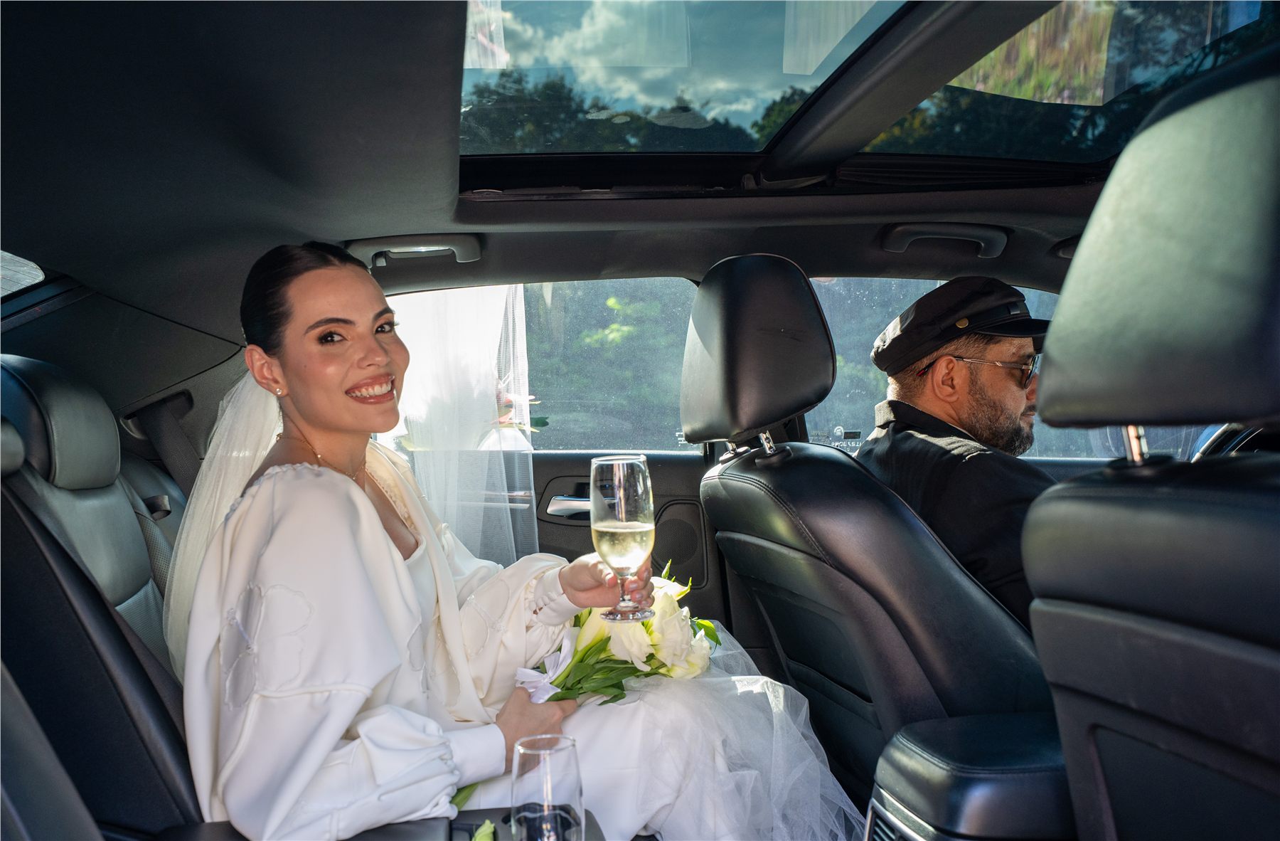 Noiva sorrindo no interior do Chrysler 300C com motorista